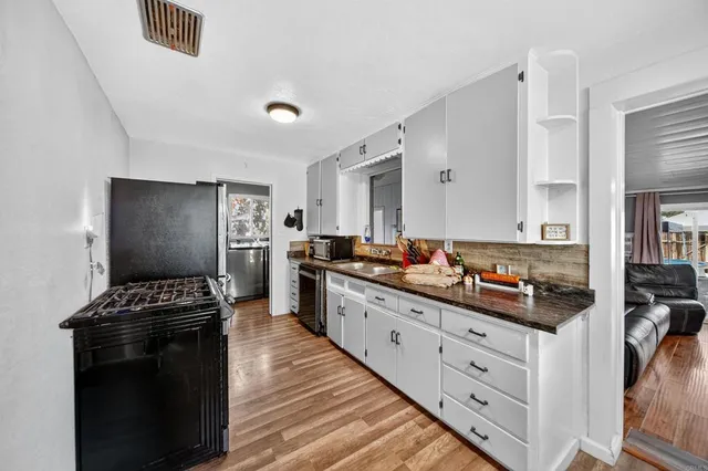 a kitchen with a refrigerator and a stove top oven