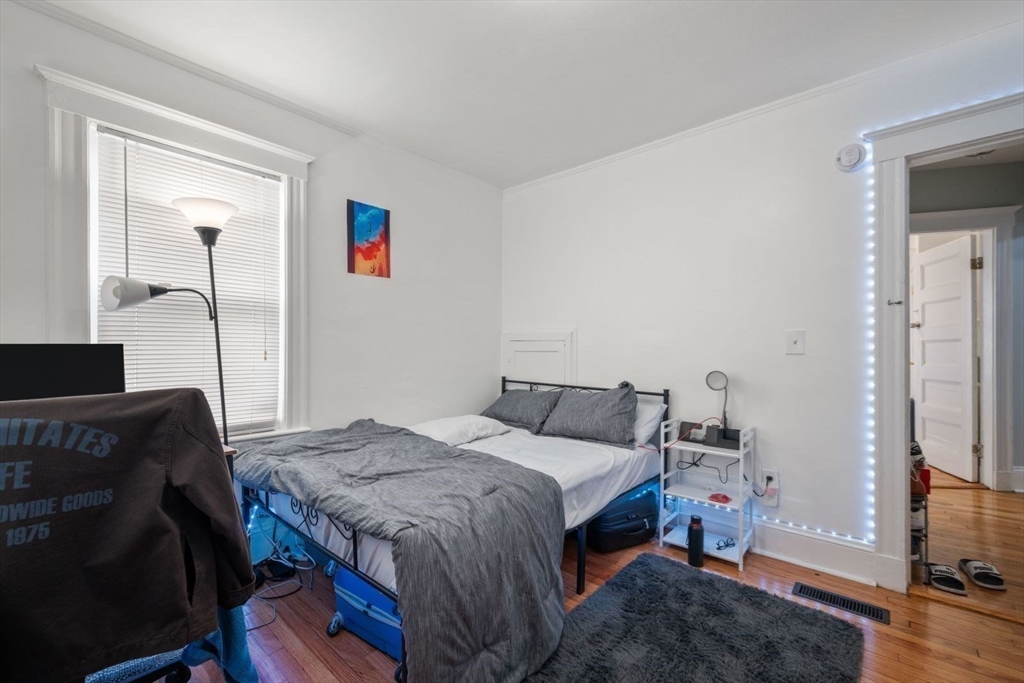 18 Claymoss Road, Unit 1 Boston, MA 02135 - Photo 12 of 24 a bedroom with a bed and a flat tv screen on a dresser