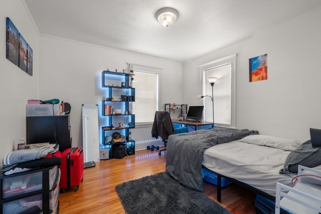 18 Claymoss Road, Unit 1 Boston, MA 02135 - Photo 13 of 24 a bedroom with a bed and wooden floor