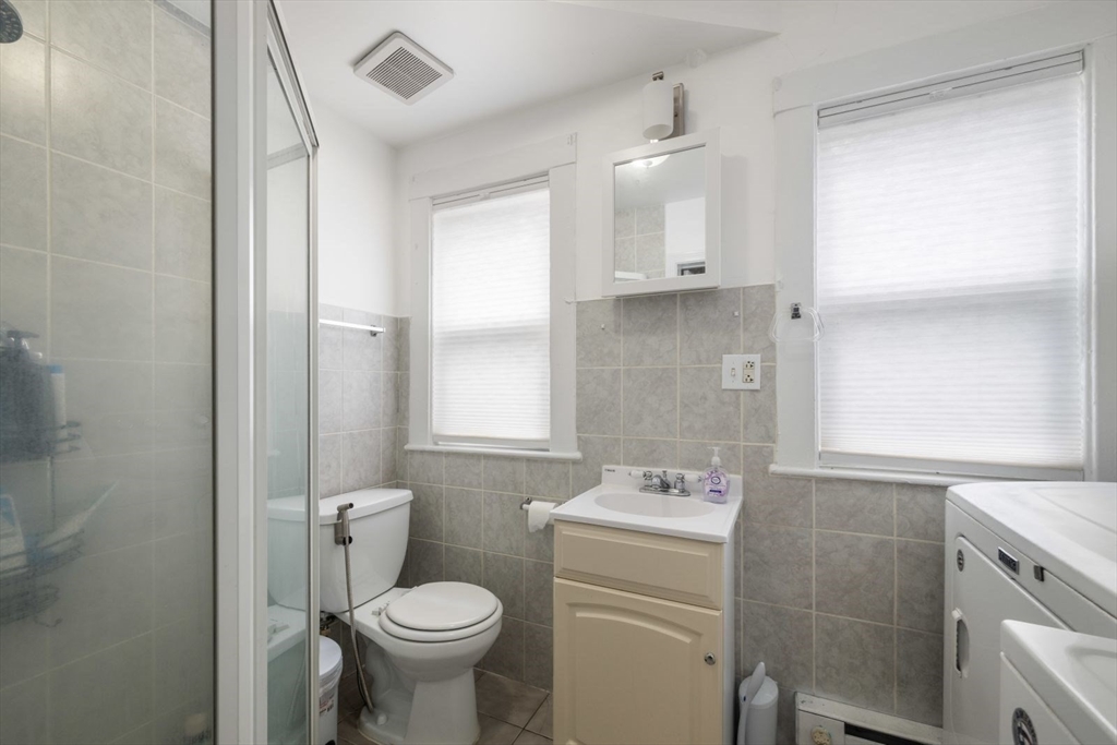 18 Claymoss Road, Unit 1 Boston, MA 02135 - Photo 19 of 24 a bathroom with a toilet sink and mirror