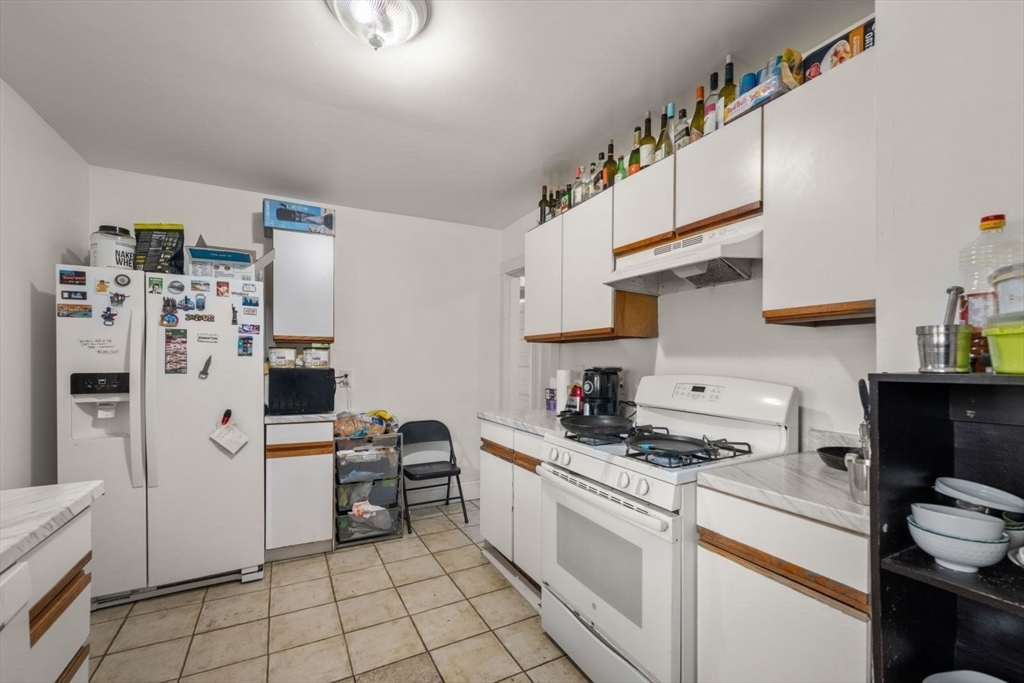18 Claymoss Road, Unit 1 Boston, MA 02135 - Photo 5 of 24 a kitchen with refrigerator a stove a sink and cabinets