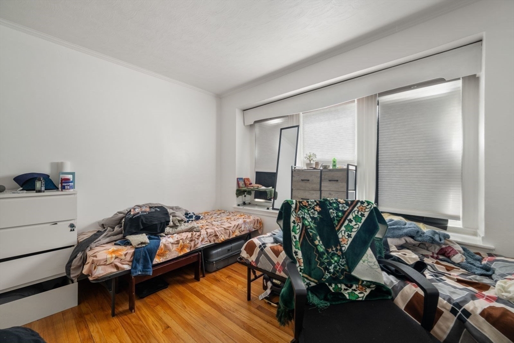 18 Claymoss Road, Unit 1 Boston, MA 02135 - Photo 10 of 24 a bedroom with a bed table flowerpot and window