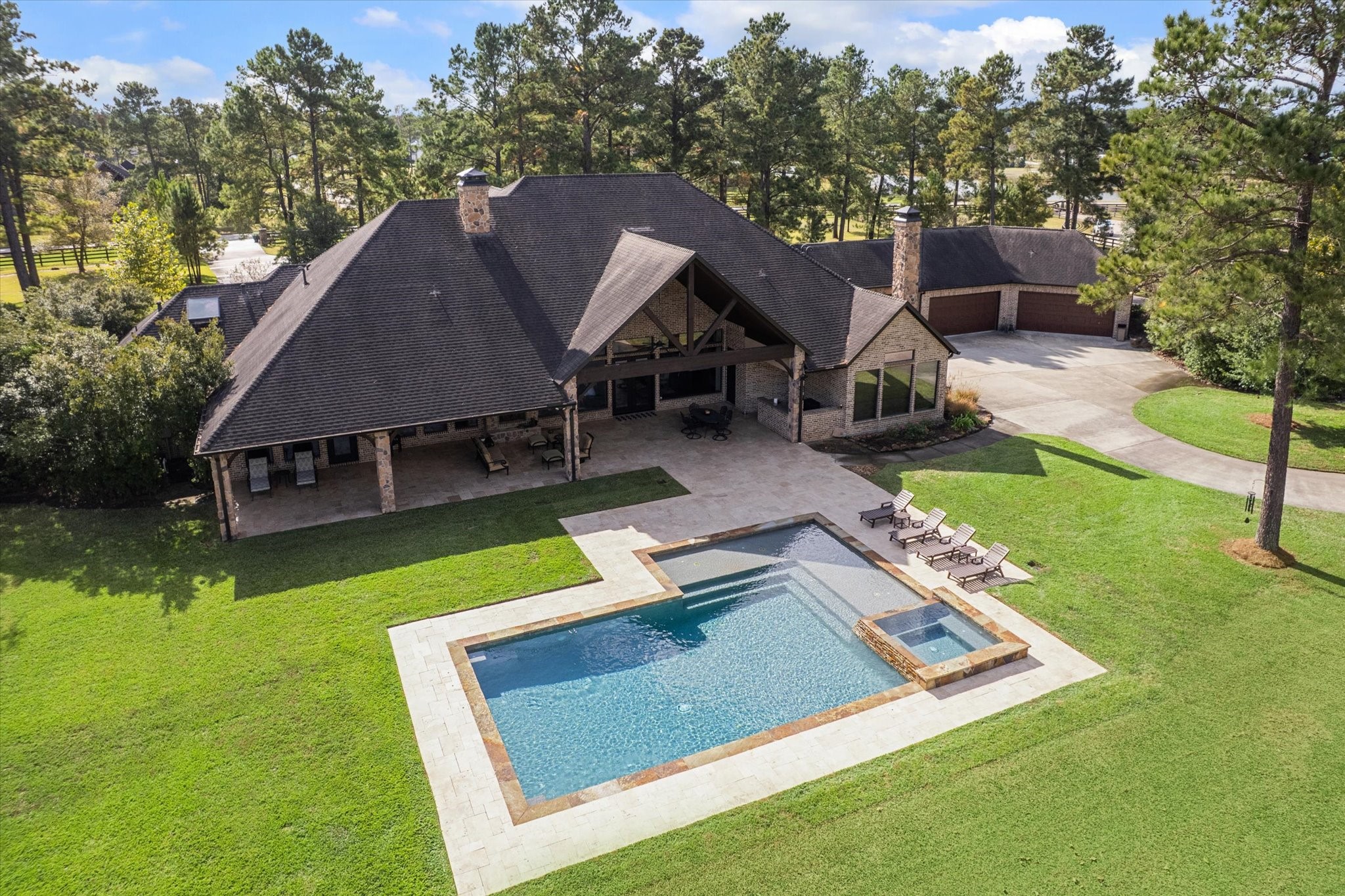 11 Willowcreek Ranch Road Tomball, TX 77377 - Photo 13 of 49 The rear elevation of the property is as pleasing as the front. It boasts clean lines, stone accents, cedar beams, travertine decking and clean lines. The large motor court and garages are discreetly positioned so as not to be viewed from the front elevation. The motor court is generously sized so that it provides easy access to navigate in and out of the oversized four car garage as well as to access the barn beyond.