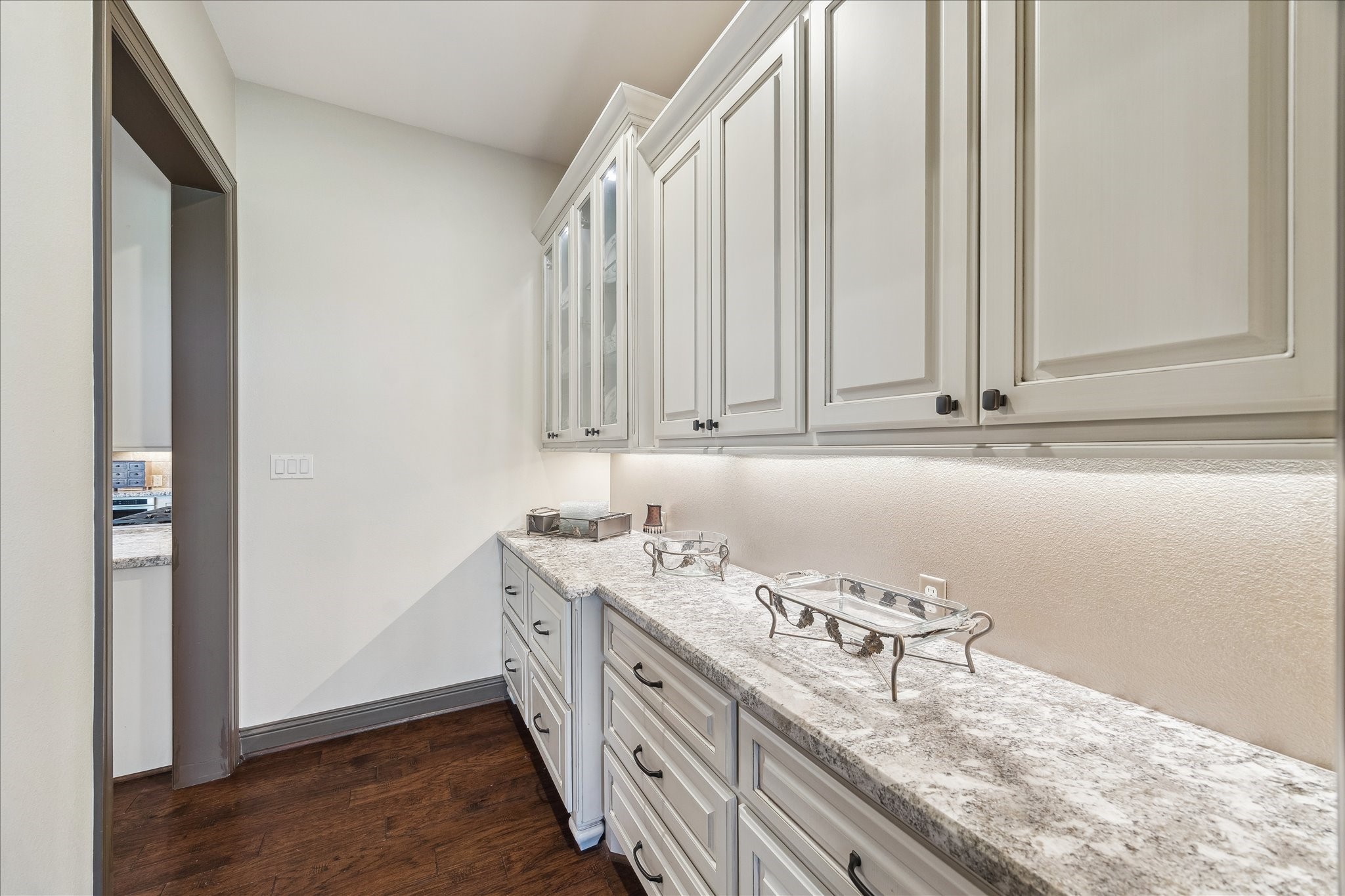 11 Willowcreek Ranch Road Tomball, TX 77377 - Photo 24 of 49 Just beyond the kitchen is the butler’s pantry with additional drawer and cabinet storage, also finished with granite countertops and undercabinet lighting.