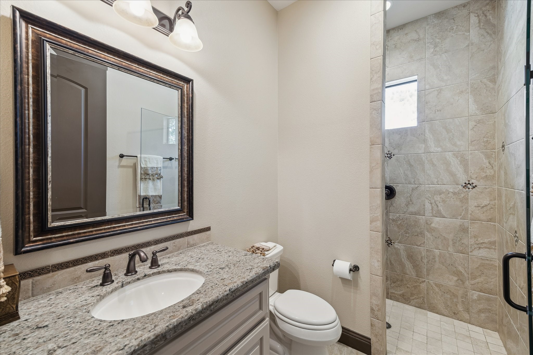 11 Willowcreek Ranch Road Tomball, TX 77377 - Photo 31 of 49 This secondary en suite bath boasts a walk in shower, granite countertops and oil rubbed bronze hardware.