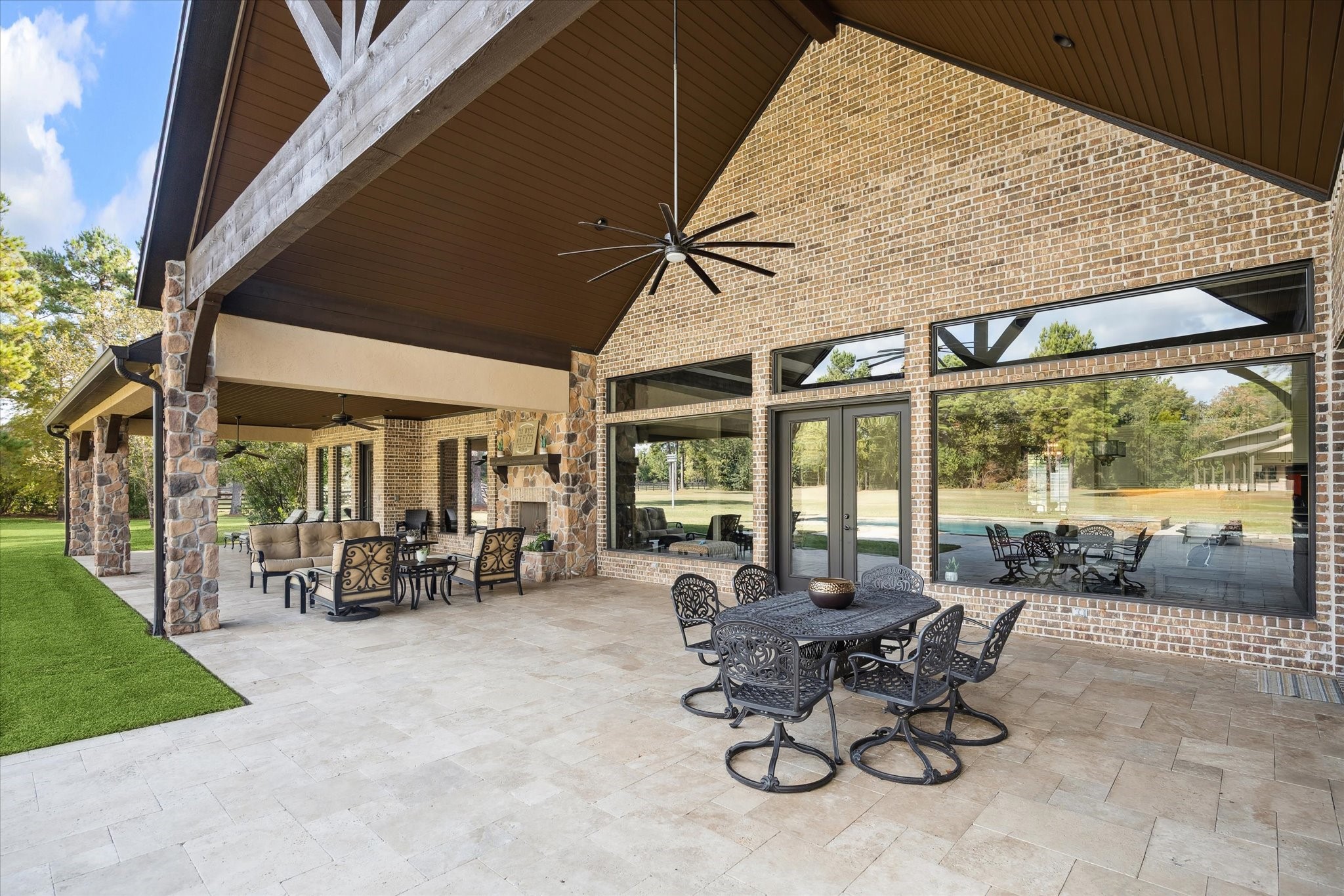 11 Willowcreek Ranch Road Tomball, TX 77377 - Photo 45 of 49 The abundance of the covered outdoor living space enables the homeowners to truly enjoy the serenity of the outdoors. Tongue and groove wood ceilings complement the stucco, brick and stone exterior. Large fans keep the air moving while the stone fireplace creates a focal point and warmth on crisp winter nights.