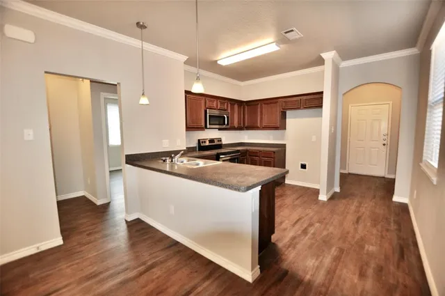 a kitchen with stainless steel appliances granite countertop a refrigerator and a stove top oven