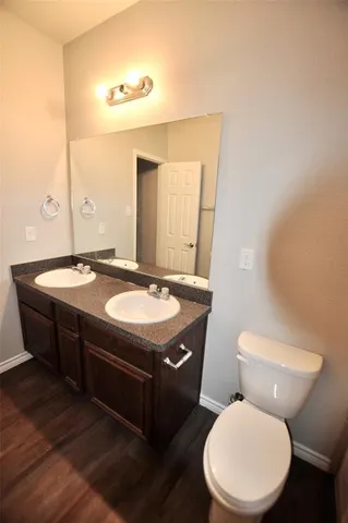 a bathroom with a granite countertop toilet sink and mirror