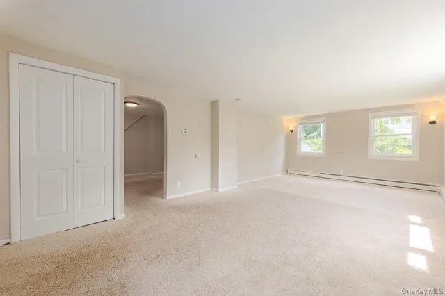 an empty room with windows and closet