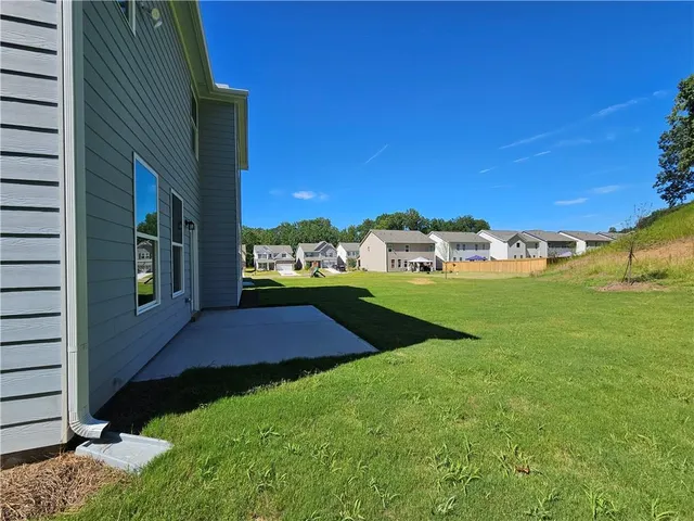 a view of a large yard with swimming pool and green space