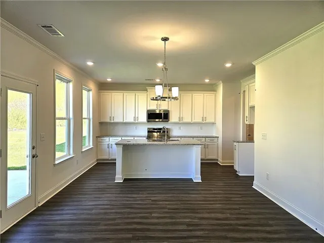 a kitchen with a refrigerator and wooden floor