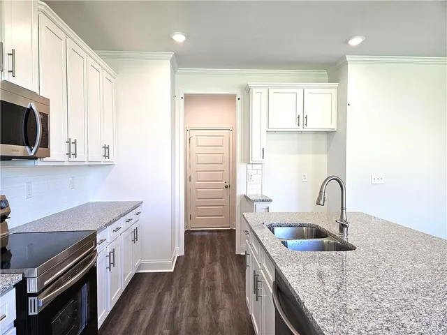 a kitchen with stainless steel appliances granite countertop a sink stove and refrigerator