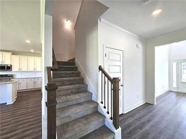 a view of a hallway with wooden floor and staircase