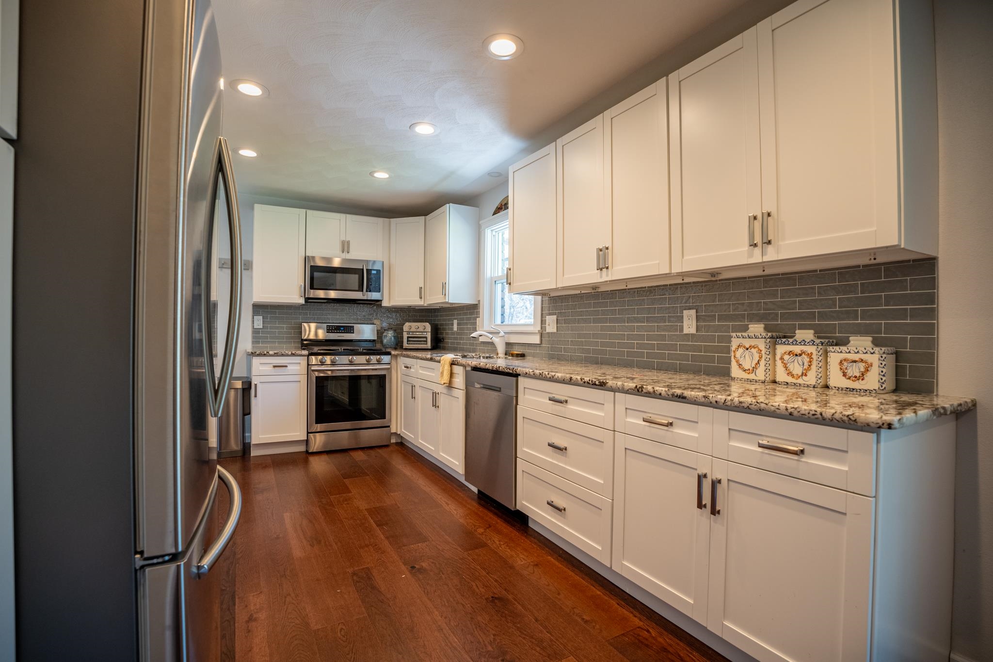 5968 East Bradley Road Byron, IL 61010 - Photo 12 of 40 a kitchen with granite countertop white cabinets and white appliances