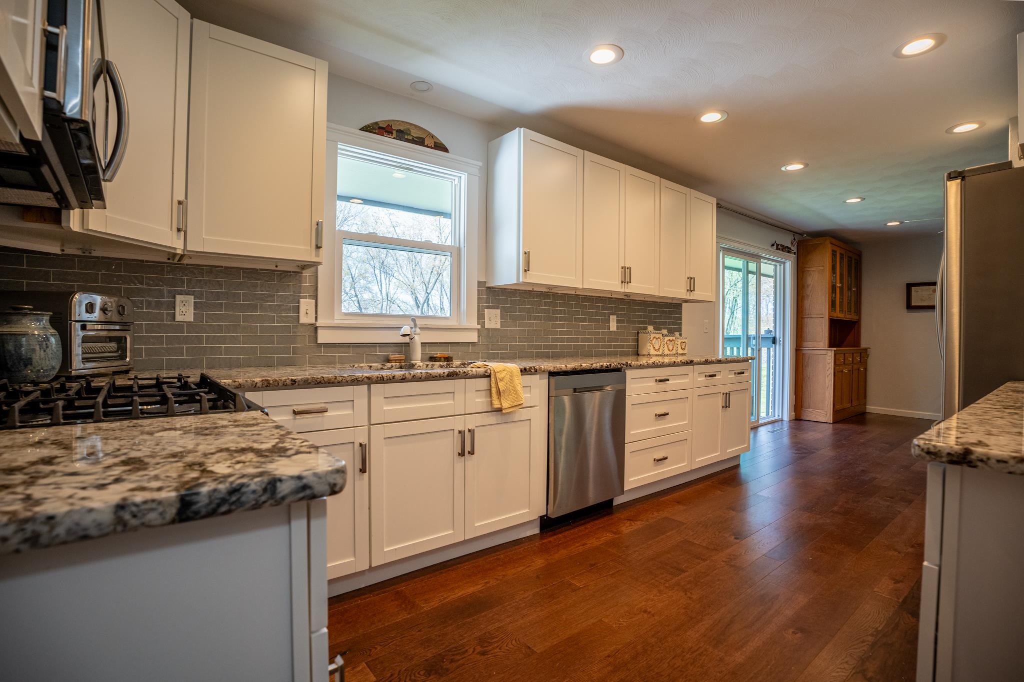 5968 East Bradley Road Byron, IL 61010 - Photo 15 of 40 a kitchen with stainless steel appliances granite countertop a stove a sink and a microwave