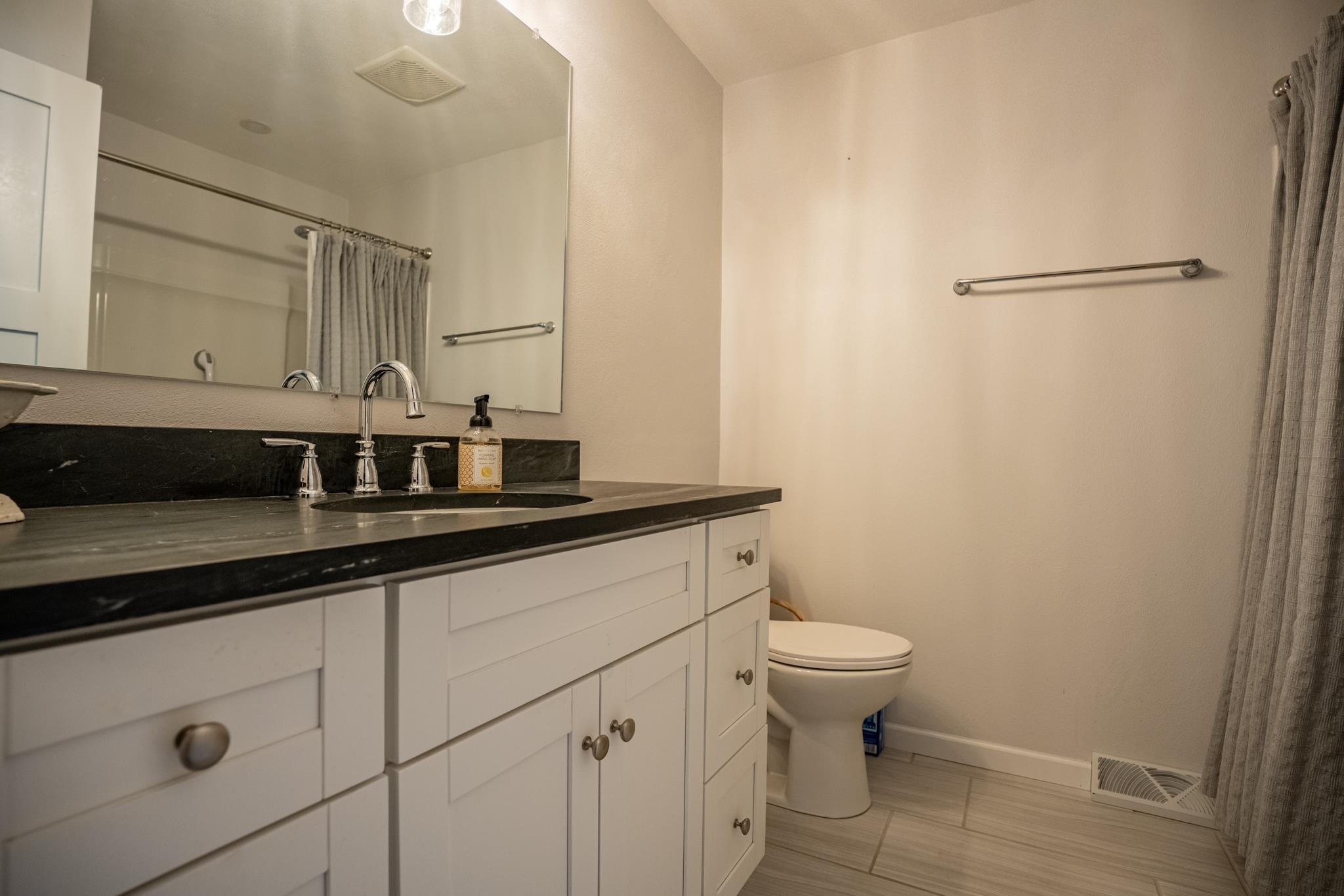 5968 East Bradley Road Byron, IL 61010 - Photo 23 of 40 a bathroom with a granite countertop sink a toilet and a mirror