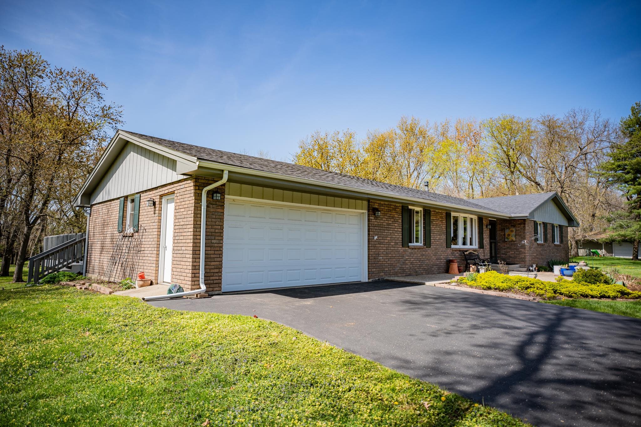 5968 East Bradley Road Byron, IL 61010 - Photo 3 of 40 a front view of a house with a yard and trees