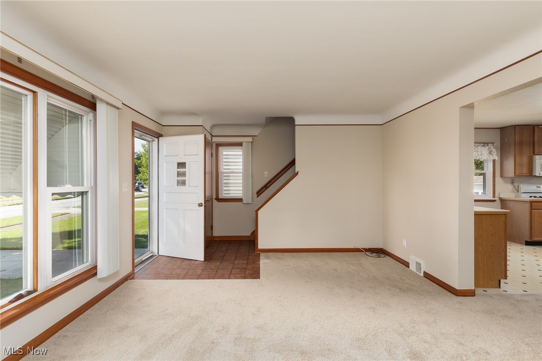 Carpeted entrance foyer with a healthy amount of sunlight