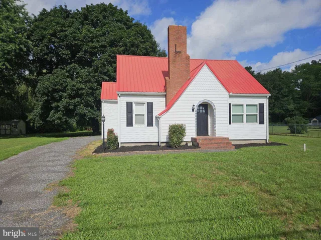 a front view of a house with a garden and yard