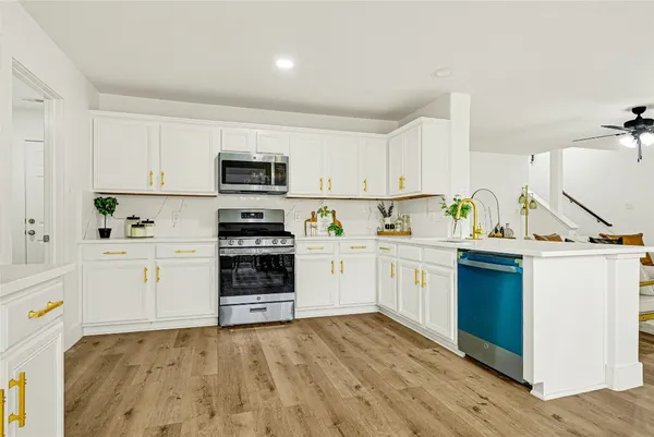 a kitchen with white cabinets and appliances