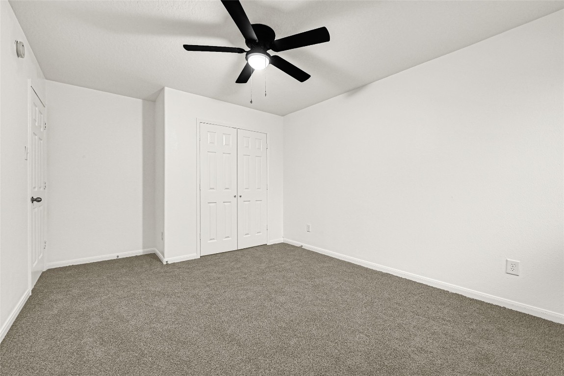1914 Rock Ridge Drive Houston, TX 77049 - Photo 14 of 26 an empty room with a ceiling fan and carpet