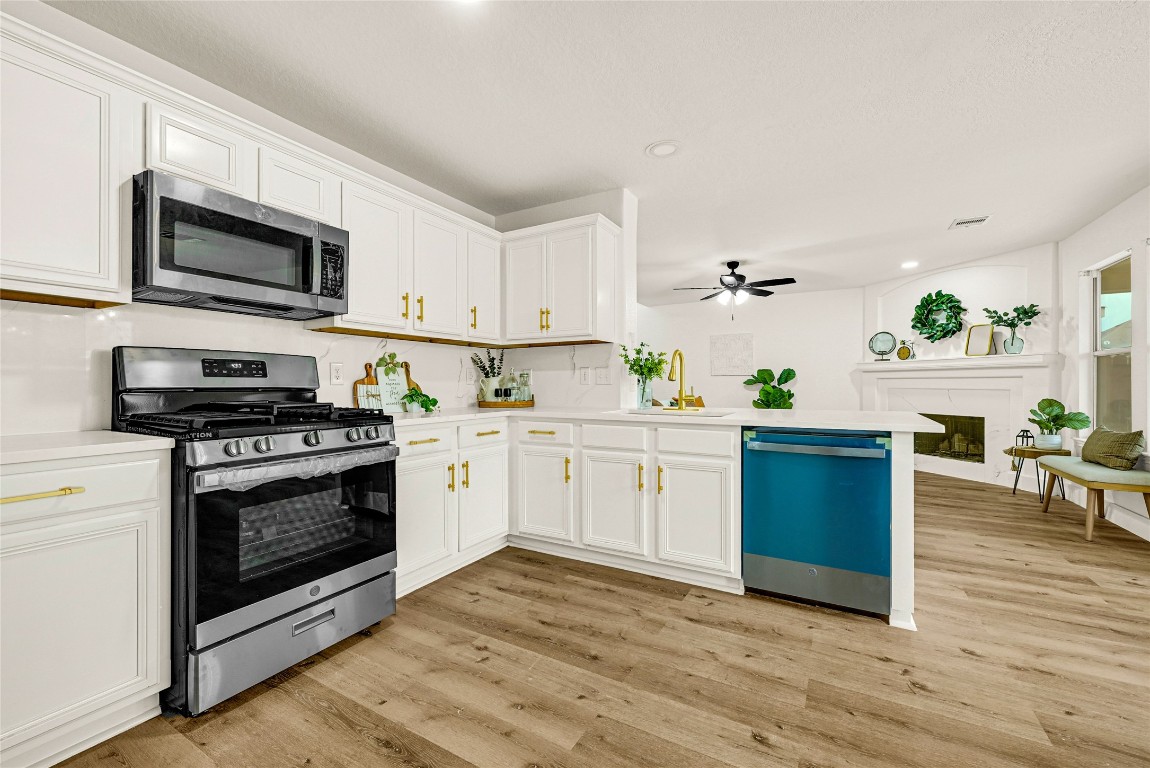 1914 Rock Ridge Drive Houston, TX 77049 - Photo 21 of 26 a kitchen with stainless steel appliances white cabinets a stove a sink and a microwave