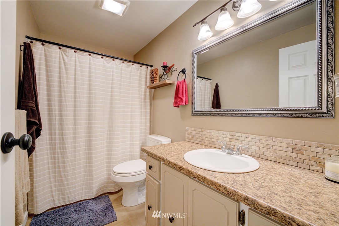 21515 4th Avenue West, Unit A72 Bothell, WA 98021 - Photo 25 of 36 a bathroom with a granite countertop sink and a mirror