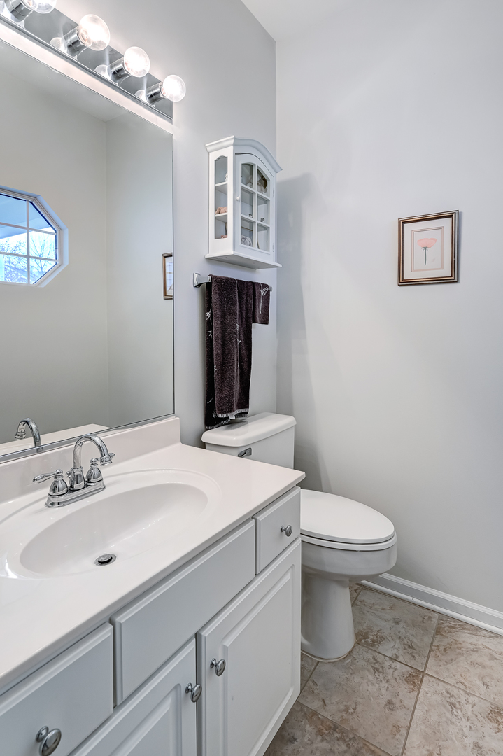 8150 Ripple Ridge Darien, IL 60561 - Photo 7 of 14 a bathroom with a sink a toilet and mirror