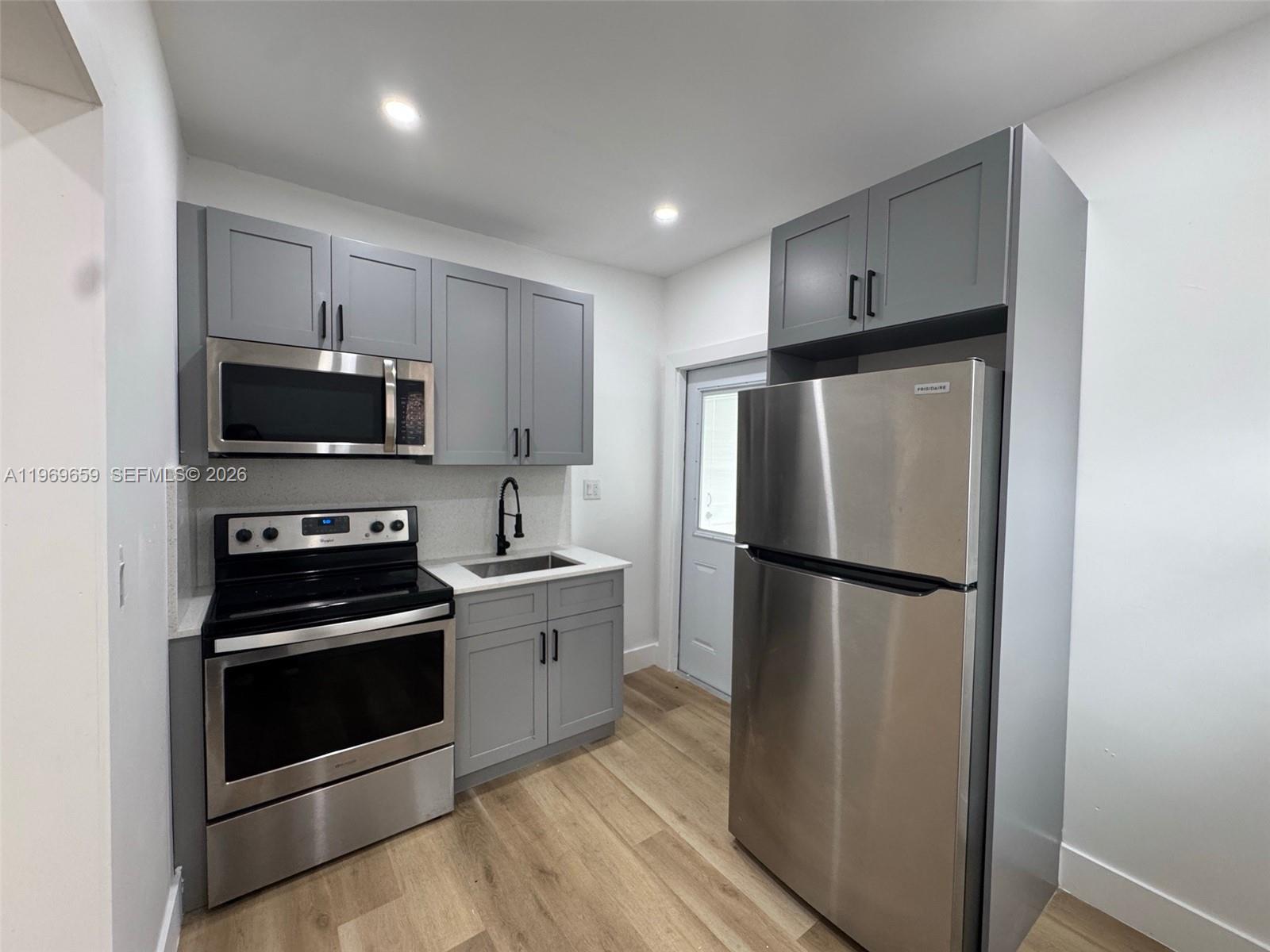 4028 Southwest 11th Street, Unit 4B Miami, FL 33134 - Photo 5 of 10 a kitchen with a refrigerator sink and stove top oven