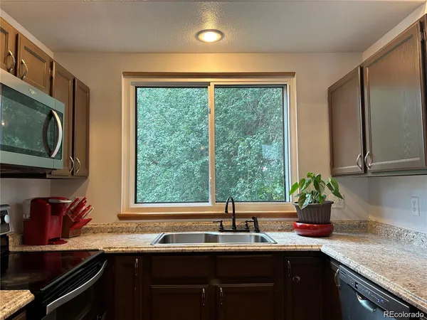 a kitchen with stainless steel appliances a refrigerator and a window