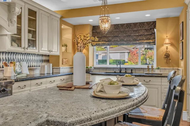 a kitchen with kitchen island granite countertop a sink and a stove