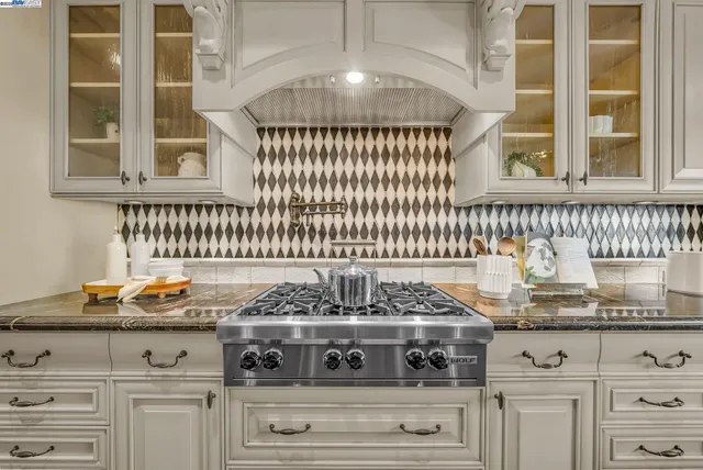 a kitchen with a stove and white cabinets