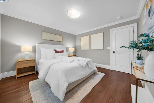 a bedroom with a bed and wooden floor