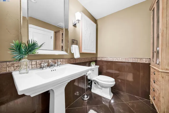 a bathroom with a sink a toilet and a mirror