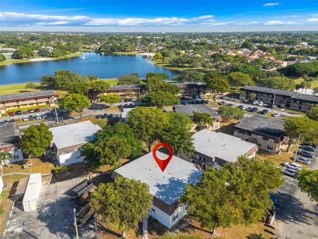 an aerial view of residential houses with outdoor space and ocean view