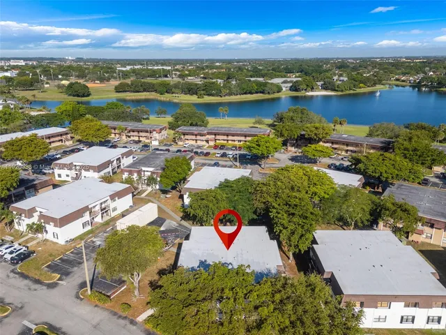 an aerial view of residential houses with outdoor space and ocean view