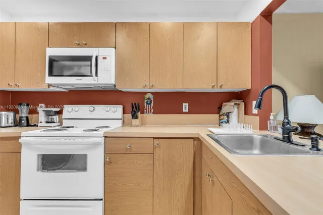 a kitchen with cabinets appliances a sink and a counter top space