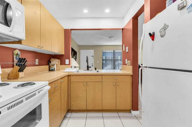 a kitchen with a sink a refrigerator and cabinets