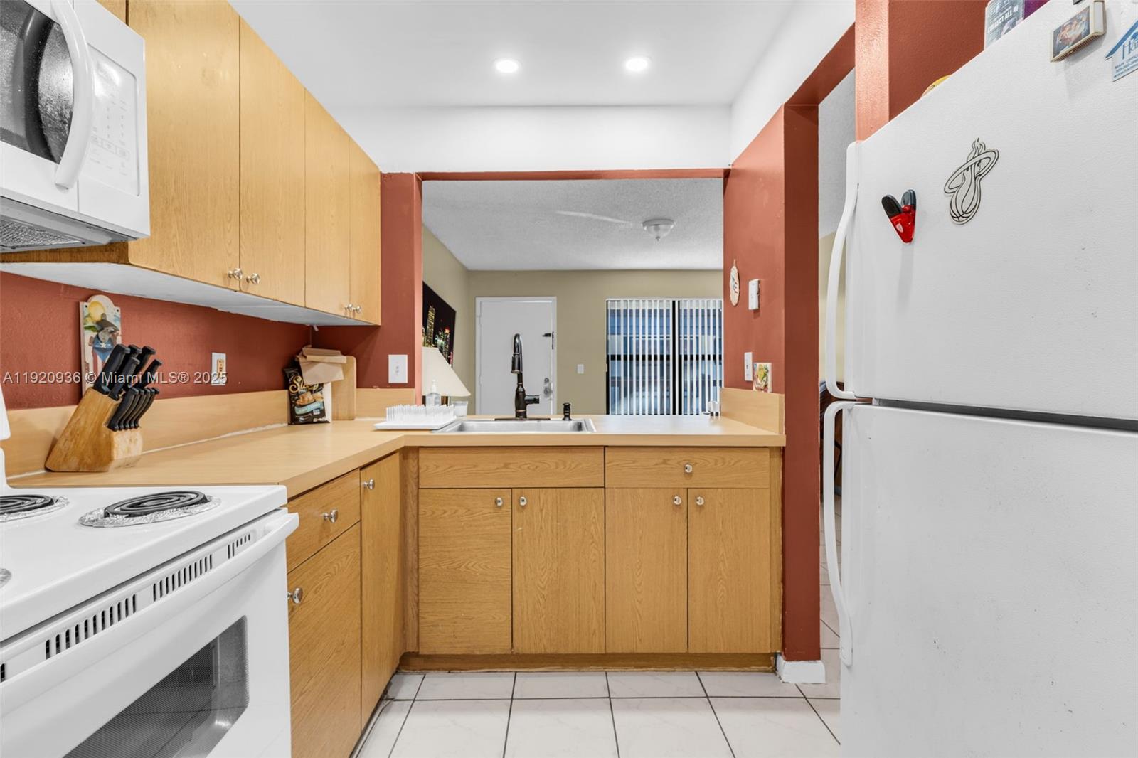 14865 Southwest 104th Street, Unit 2622 Miami, FL 33196 - Photo 10 of 24 a kitchen with a sink a refrigerator and cabinets