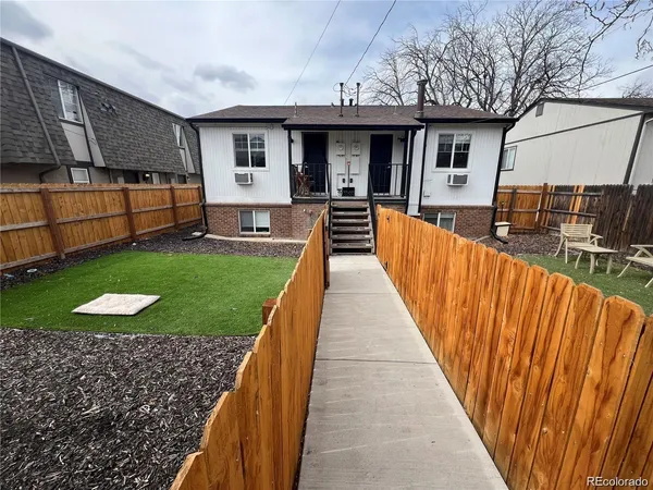 a view of a house with backyard and sitting area