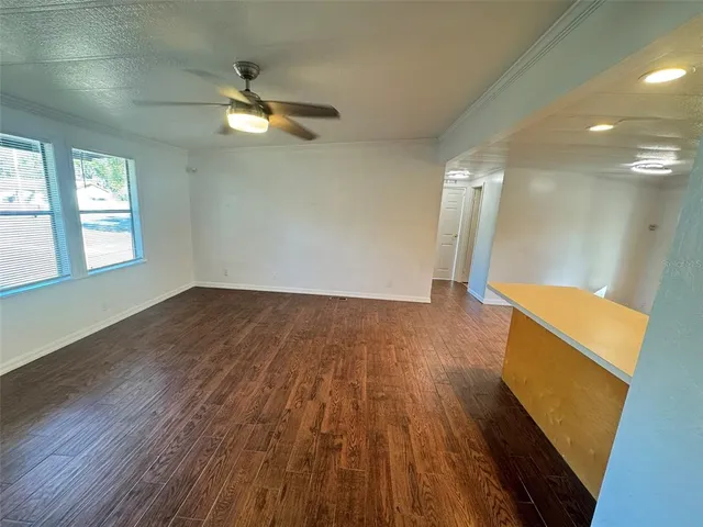 a view of empty room with wooden floor