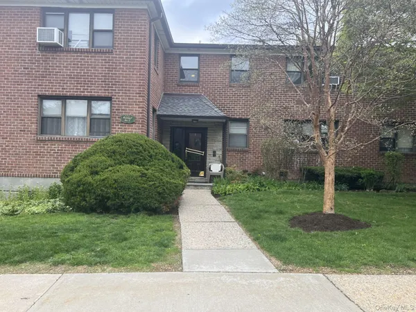 a front view of a house with a garden and yard