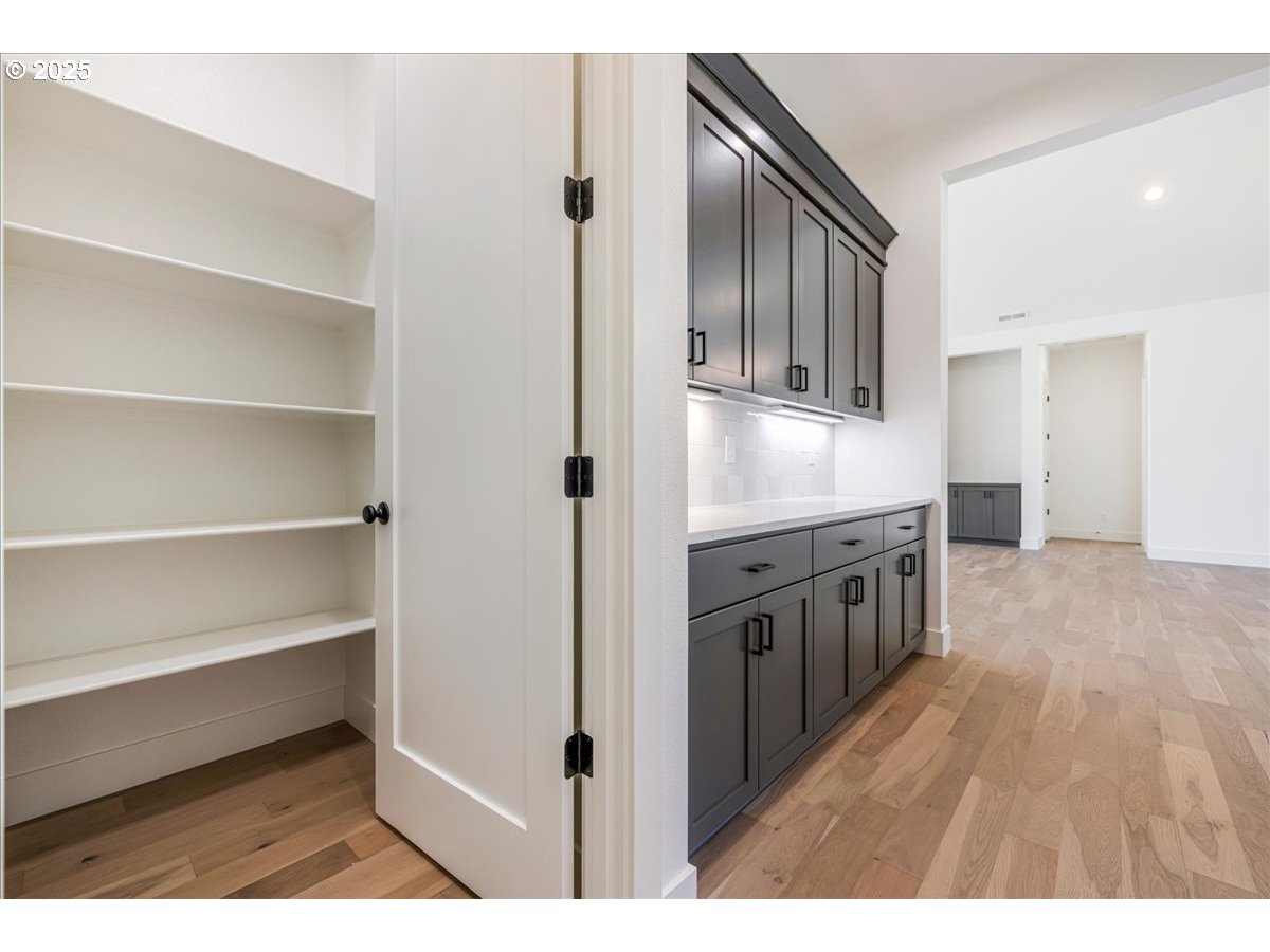 7168 Southeast Eola Hills Road Amity, OR 97101 - Photo 22 of 34 a kitchen with stainless steel appliances granite countertop a refrigerator a stove and a sink with wooden floor