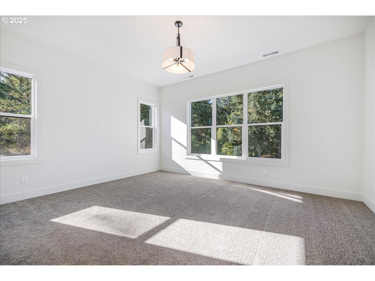 7168 Southeast Eola Hills Road Amity, OR 97101 - Photo 23 of 34 a view of an empty room with wooden floor and windows