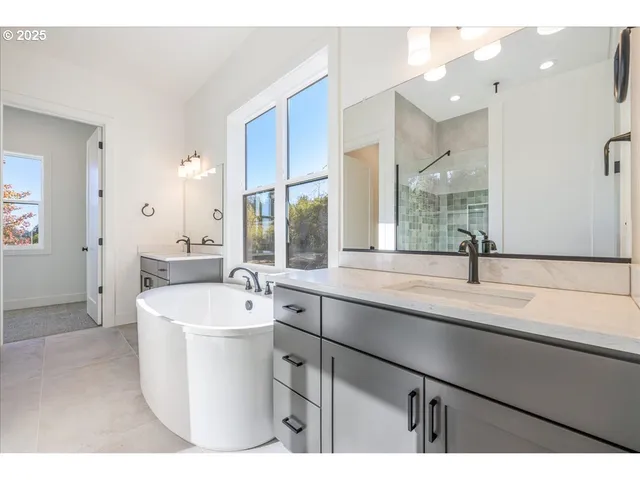 a spacious bathroom with a sink a mirror and a bathtub