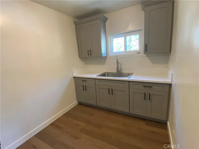 a kitchen with sink cabinets and wooden floor