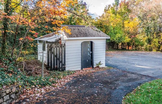 a view of a house with a small yard and large tree