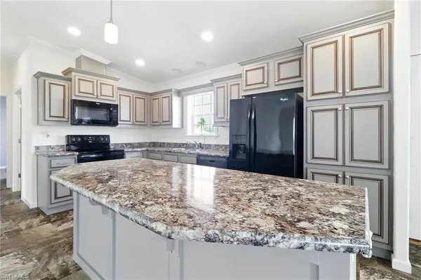 a kitchen with stainless steel appliances granite countertop a refrigerator stove microwave and sink