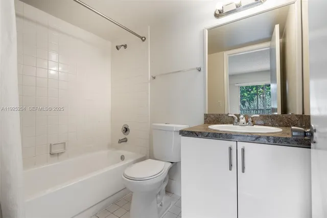 a bathroom with a granite countertop sink a toilet and shower