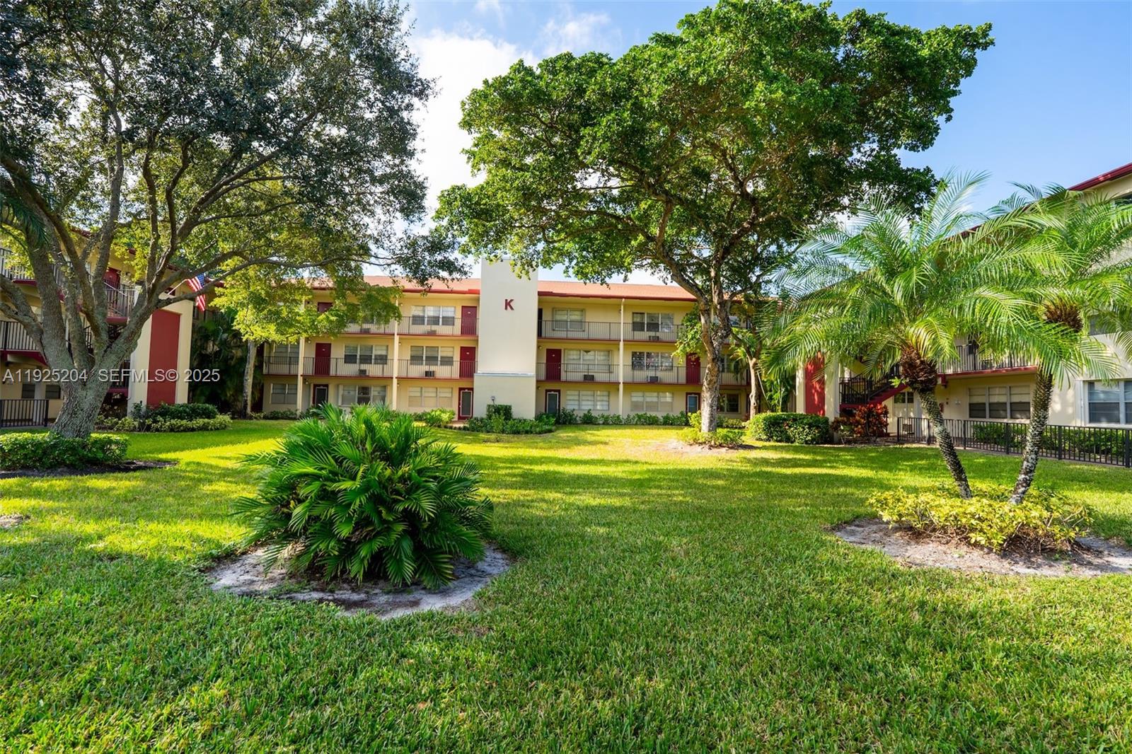 100 Southwest 132nd Way, Unit 306K Pembroke Pines, FL 33027 - Photo 23 of 31 a view of a house with a big yard potted plants and a large tree